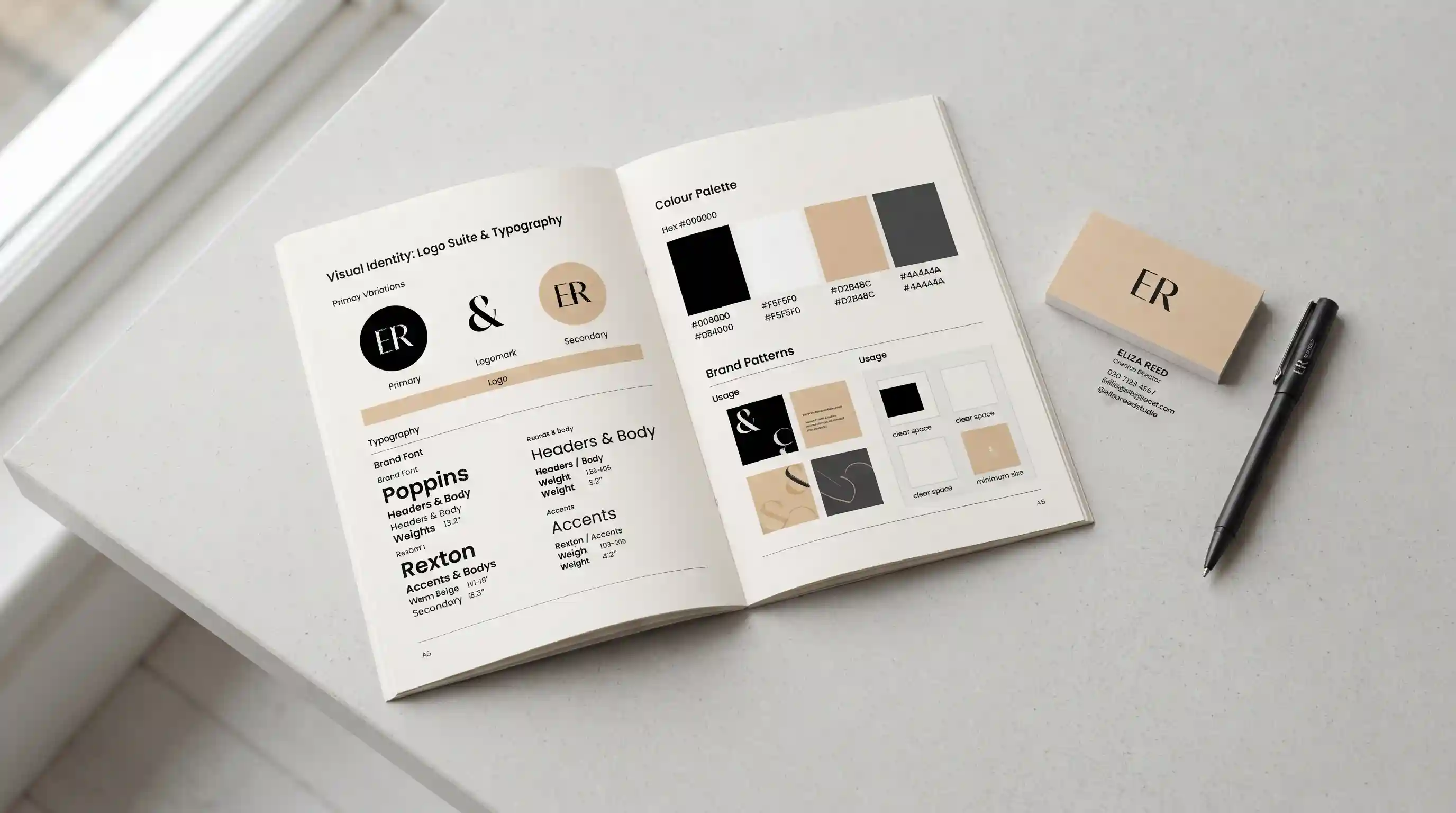 Open brand guidelines booklet showing colour swatches and logo variations on a clean desk